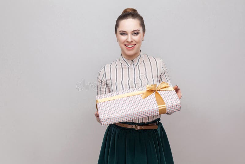 Dobroci atrakcyjna młoda dorosła kobieta w bielu z zielonej liny spódnicową pozycją dawać ci teraźniejszości z żółtym łękiem i i fotografia royalty free Dobroci atrakcyjna młoda dorosła kobieta w bielu z zielonej liny spódnicową pozycją dawać ci teraźniejszości z żółtym łękiem i i fotografia royalty free