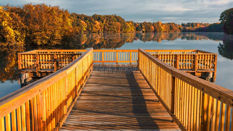 Doca de madeira sobre a lagoa ou o lago no outono da queda em Connecticut EUA foto de stock Doca de madeira sobre a lagoa ou o lago no outono da queda em Connecticut EUA foto de stock
