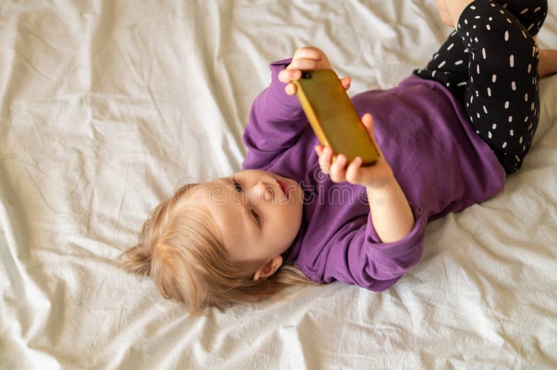 Doce menina jogando jogo no smartphone