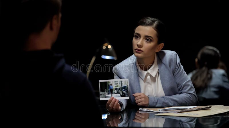 Dochodzenie oficer pokazuje morderstwo podejrzany ofiary fotografię, milicyjny przesłuchanie zdjęcia stock