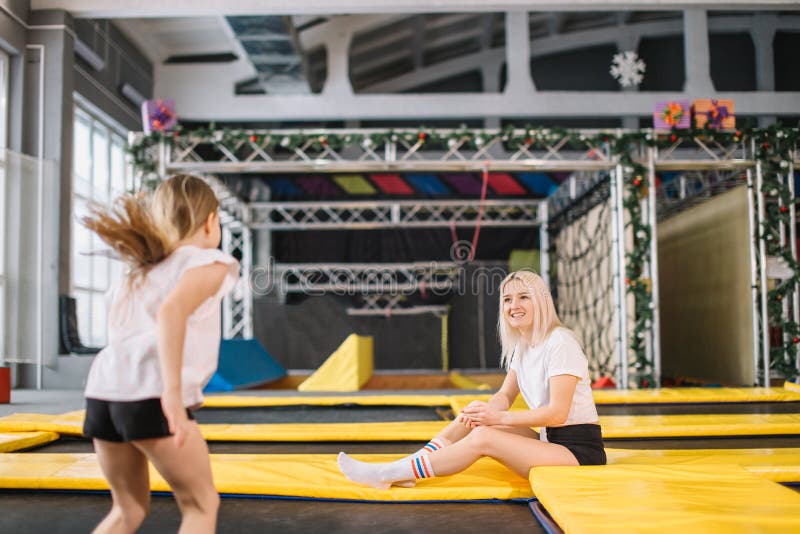 Dochter die op Trampoline stuiteren terwijl Moederhorloge voor veiligheid royalty-vrije stock afbeelding Dochter die op Trampoline stuiteren terwijl Moederhorloge voor veiligheid royalty-vrije stock afbeelding