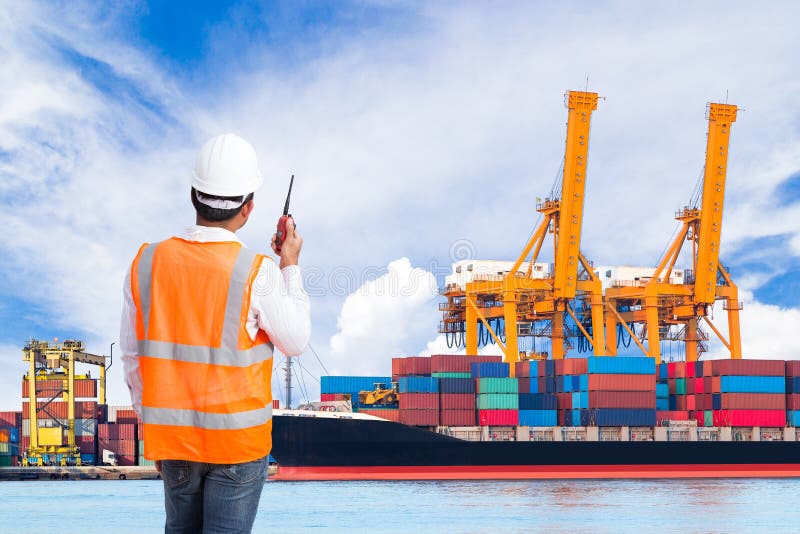 Dock worker talking on the walkie-talkie for controlling loading stock image Dock worker talking on the walkie-talkie for controlling loading stock image