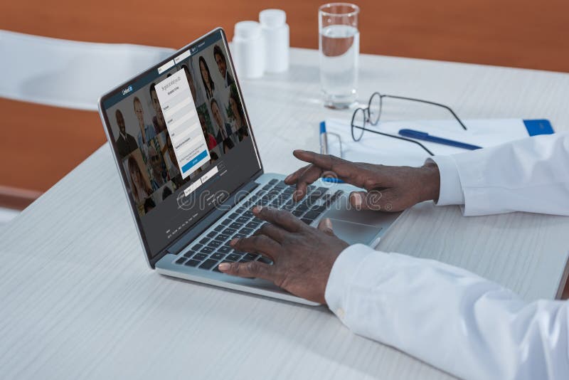 Cropped image of african american doctor with loaded LinkedIn website. Cropped image of african american doctor with loaded LinkedIn website