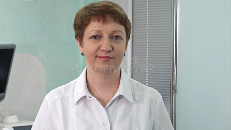 Docteur de femme souriant et regardant à l'appareil-photo photographie stock libre de droits Docteur de femme souriant et regardant à l'appareil-photo photographie stock libre de droits