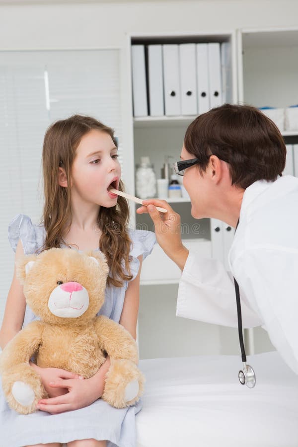 Docteur examinant la bouche de petite fille