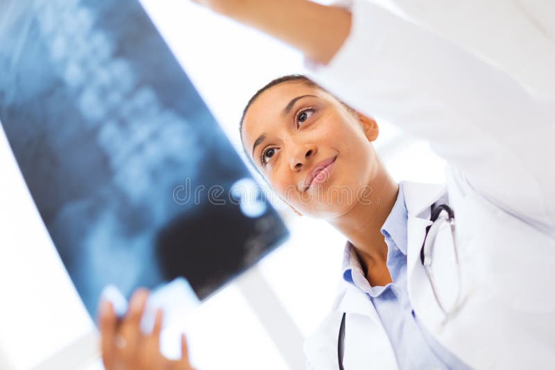 Docteur féminin de sourire étudiant le rayon X images stock Docteur féminin de sourire étudiant le rayon X images stock