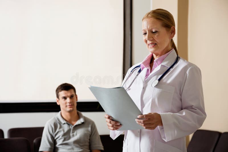 Docteur féminin Looking At File photo stock Docteur féminin Looking At File photo stock