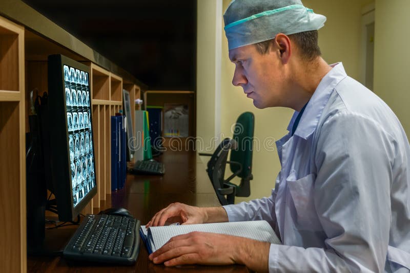 Docteur Looking au moniteur sur la permanence de nuit image stock Docteur Looking au moniteur sur la permanence de nuit image stock