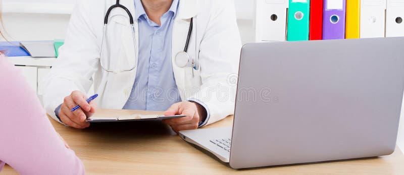 Docteur masculin ? la table ?coutant attentivement des plaintes patientes image stock Docteur masculin ? la table ?coutant attentivement des plaintes patientes image stock