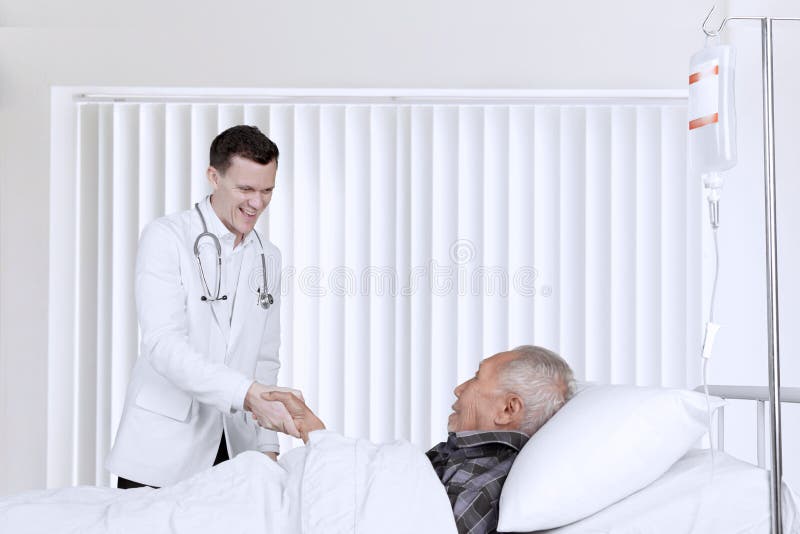 Docteur masculin serrant la main avec le patient plus âgé photo libre de droits Docteur masculin serrant la main avec le patient plus âgé photo libre de droits