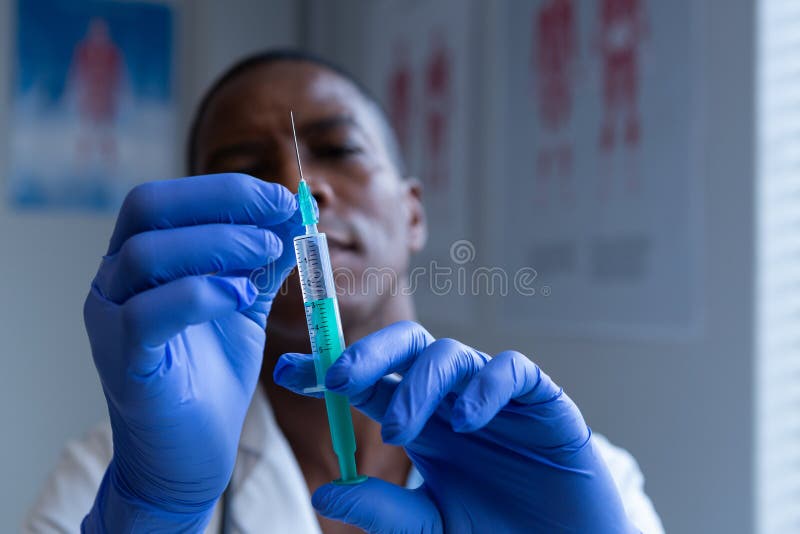 Docteur masculin tenant la seringue avec l'injection dans l'hôpital photos libres de droits Docteur masculin tenant la seringue avec l'injection dans l'hôpital photos libres de droits