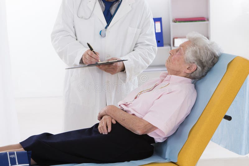 Docteur parlant à son patient supérieur handicapé photo stock Docteur parlant à son patient supérieur handicapé photo stock