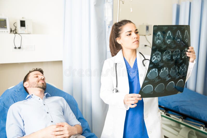 Docteur regardant des résultats de balayage de CT images stock Docteur regardant des résultats de balayage de CT images stock