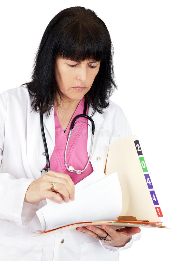 Docteur regardant le dossier médical photographie stock Docteur regardant le dossier médical photographie stock