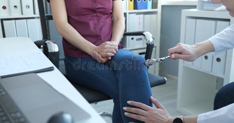 Docteur tape le genou du patient avec le marteau vérifier la réaction du jerk banque de vidéos