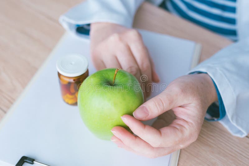 Doctor advising apple instead of pills and antibiotics royalty free stock photo Doctor advising apple instead of pills and antibiotics royalty free stock photo