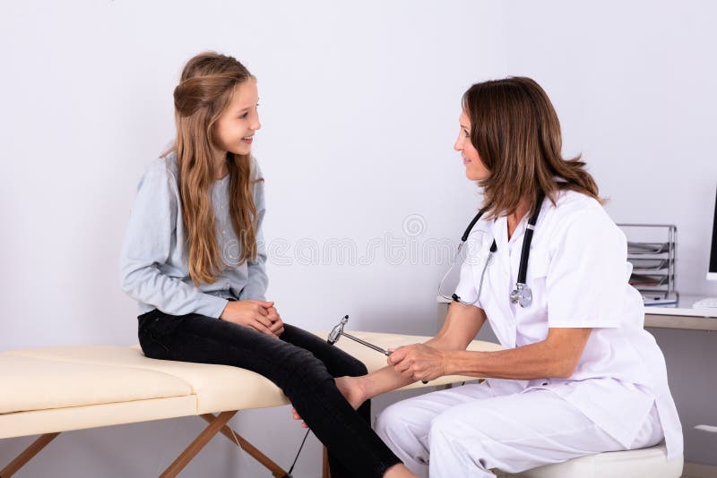 Doctor Checking Knee Reflexes Of Patient With Reflex Hammer