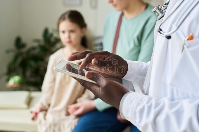 Doctor Checking Medical Records on Tablet in Clinic royalty free stock photos