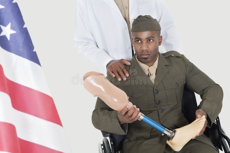 Doctor con el oficial del ejército discapacitado que sostiene el miembro artificial como él mira la bandera americana imagen de archivo libre de regalías Doctor con el oficial del ejército discapacitado que sostiene el miembro artificial como él mira la bandera americana imagen de archivo libre de regalías