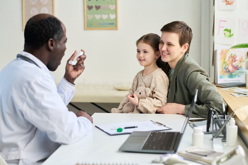 Doctor Consulting Mother and Daughter Smiling in Office stock images