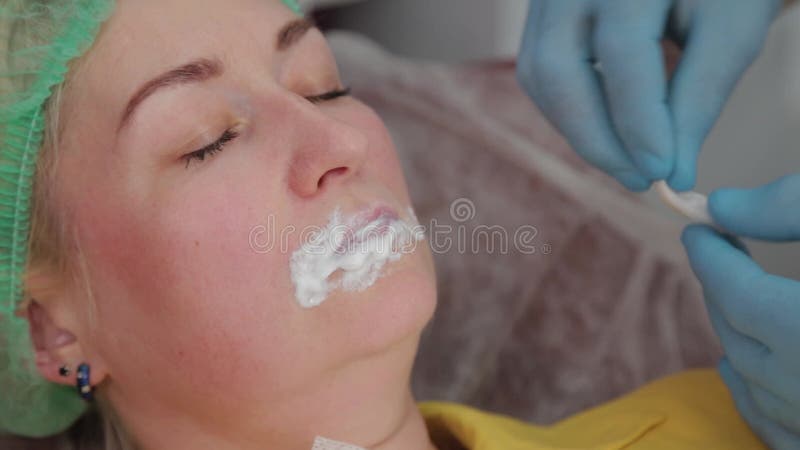 Doctor cosmetologist makes lip augmentation to woman. Cosmetologist makes video