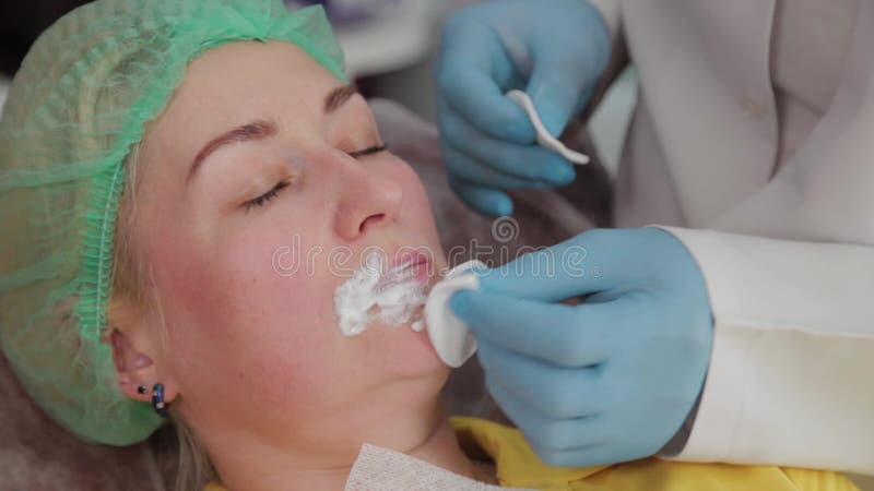 Doctor cosmetologist makes lip augmentation to woman. Cosmetologist makes video