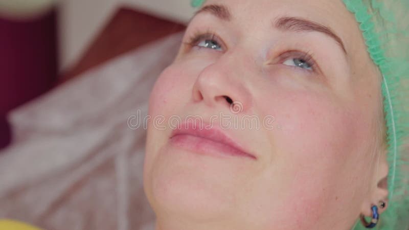 Doctor cosmetologist makes lip augmentation to woman. Cosmetologist makes video