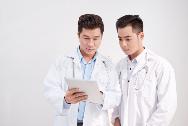 Doctor de dos mangos que mira el ipad/la tableta y que tiene una discusión imagen de archivo Doctor de dos mangos que mira el ipad/la tableta y que tiene una discusión imagen de archivo