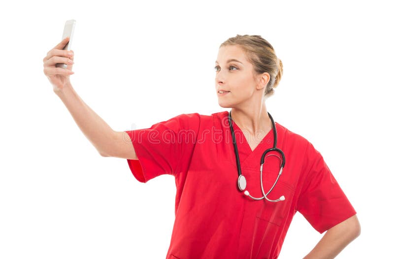 Doctor de sexo femenino atractivo que toma el selfie con smartphone foto de archivo libre de regalías Doctor de sexo femenino atractivo que toma el selfie con smartphone foto de archivo libre de regalías