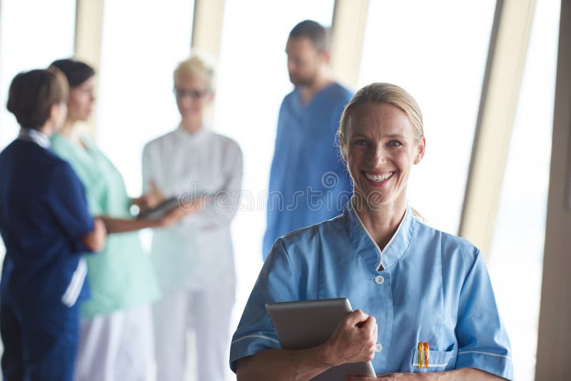 Doctor de sexo femenino con la tableta que se coloca delante del equipo imagenes de archivo Doctor de sexo femenino con la tableta que se coloca delante del equipo imagenes de archivo