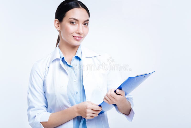 Doctor de sexo femenino hermoso que presenta con un tenedor de la hoja h fotografía de archivo libre de regalías Doctor de sexo femenino hermoso que presenta con un tenedor de la hoja h fotografía de archivo libre de regalías