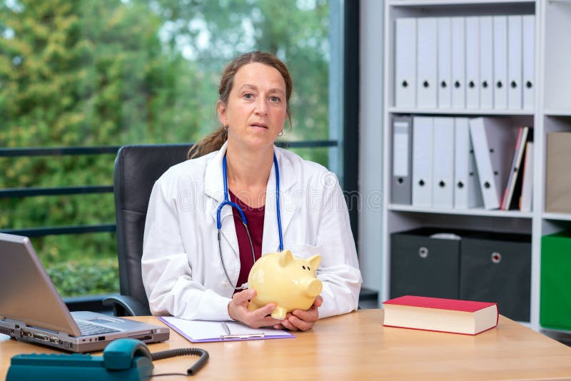 Doctor de sexo femenino joven con la hucha fotos de archivo libres de regalías Doctor de sexo femenino joven con la hucha fotos de archivo libres de regalías