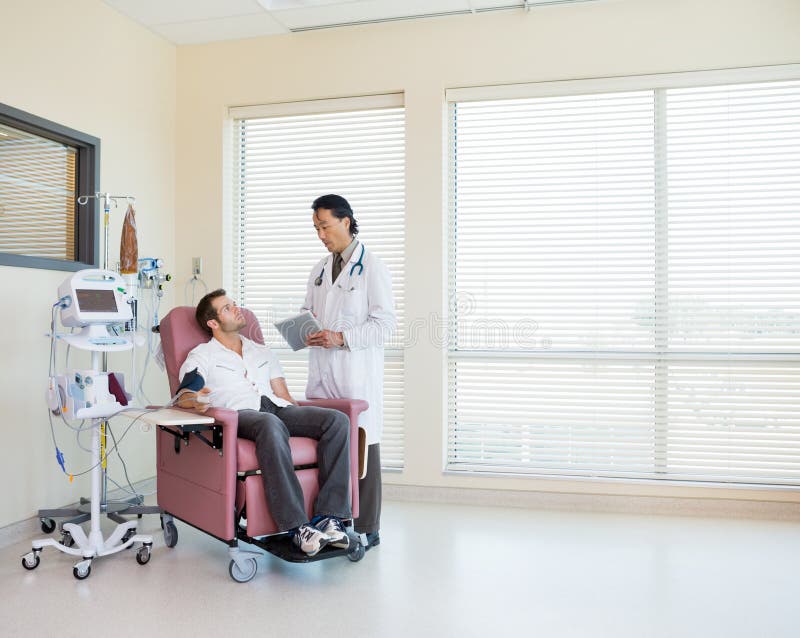 Doctor With Digital Tablet Discussing With Patient stock image Doctor With Digital Tablet Discussing With Patient stock image
