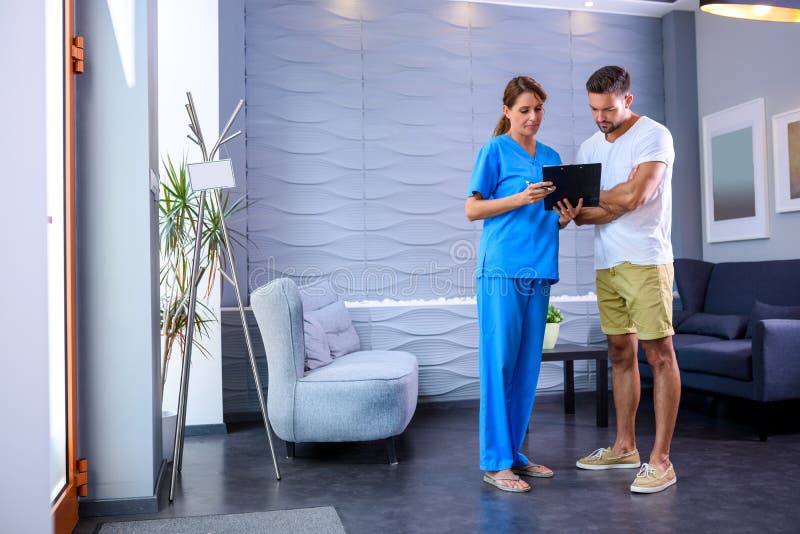 A Doctor discussing details of a medical procedure with a handsome male Patientr. A Doctor discussing details of a medical procedure with a handsome male Patientr