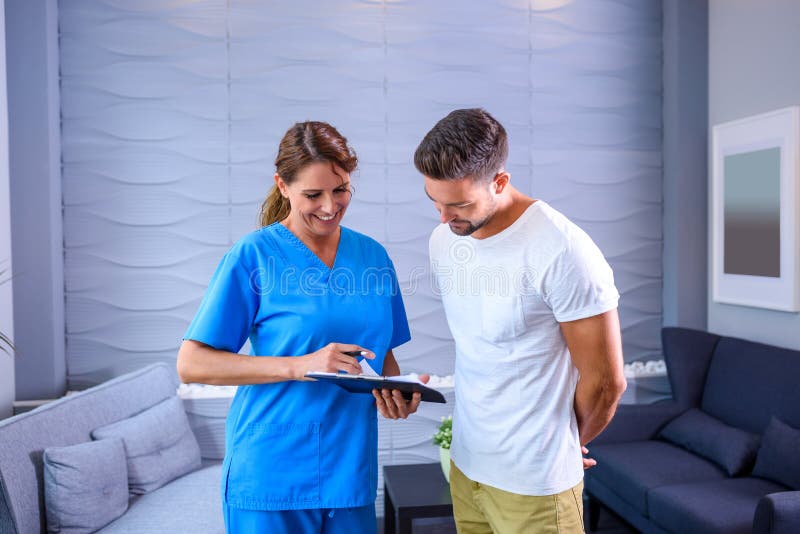 A Doctor discussing details of a medical procedure with a handsome male Patientr. A Doctor discussing details of a medical procedure with a handsome male Patientr