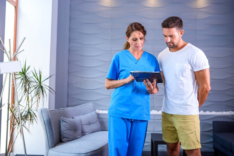 A Doctor discussing details of a medical procedure with a handsome male Patientr. A Doctor discussing details of a medical procedure with a handsome male Patientr