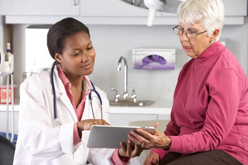 Doctor Discussing Records With Senior Female Patient stock photography