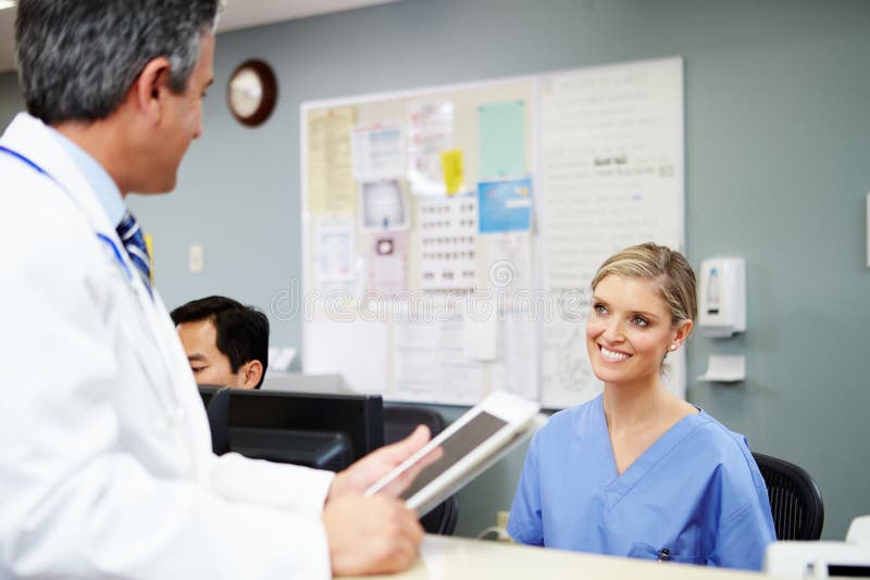 Doctor In Discussion With Nurse At Nurses Station royalty free stock photography Doctor In Discussion With Nurse At Nurses Station royalty free stock photography