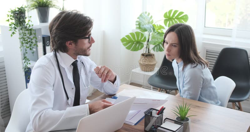 Doctor discutiendo acerca de informe médico con una mujer