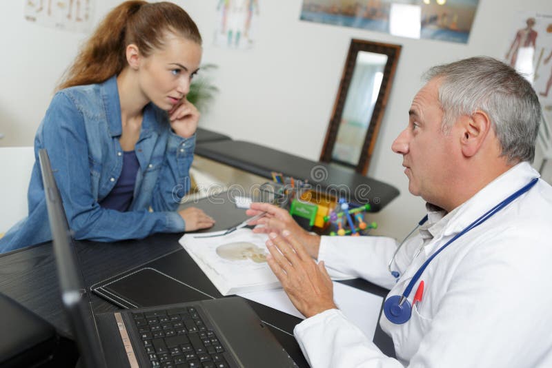 Doctor en la discusión con el paciente femenino joven fotografía de archivo
