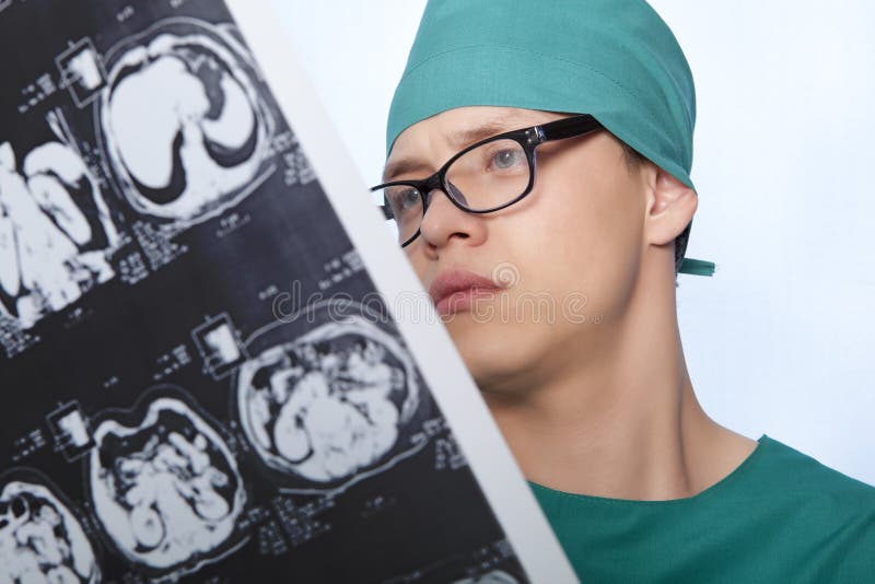 Male doctor examines X-ray picture of a human brain. Male doctor examines X-ray picture of a human brain