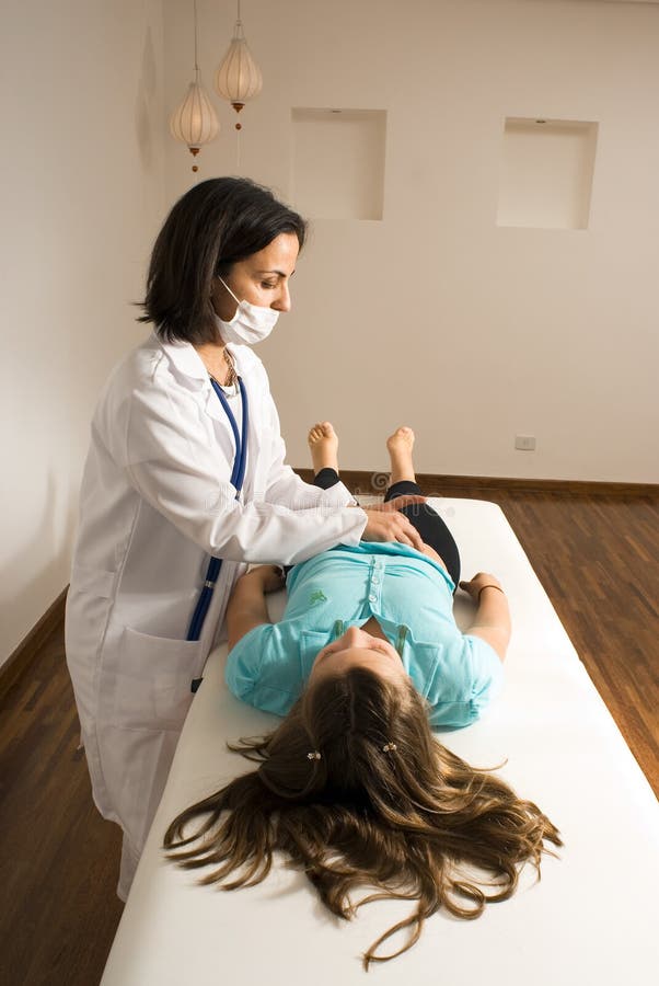 Doctor examining girl s abdomen-vertical