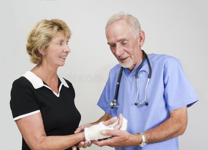 Doctor examining senior woman with hand in cast