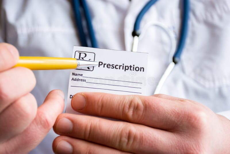 Doctor in foreground holding sample of prescription or recipe for drug, other hand indicates designation of prescription medicatio