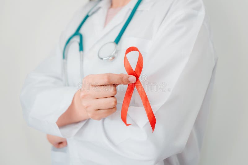 Doctor Hands is Holding Red Ribbon and Arms Crossed Posing. AIDS, HIV International Symbol of Awareness, Healthcare and Medicine