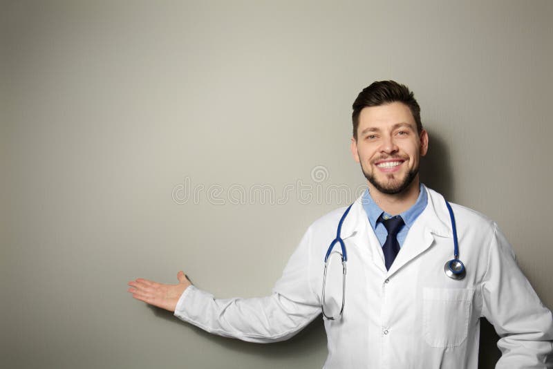 Doctor hermoso que se coloca en fondo fotos de archivo libres de regalías Doctor hermoso que se coloca en fondo fotos de archivo libres de regalías