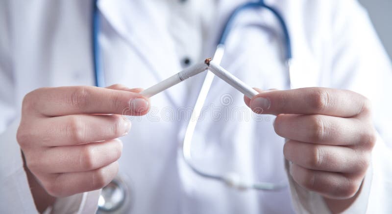 Doctor holding broken cigarette. Stop smoking