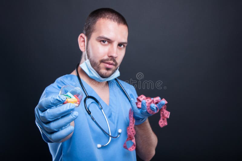 Doctor holding pills in front of measuring tape stock photos