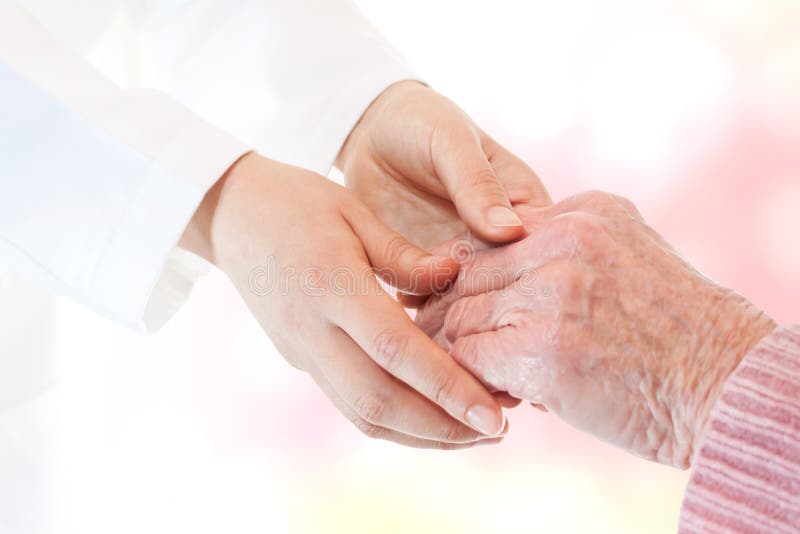 Doctor holding senior lady s hand