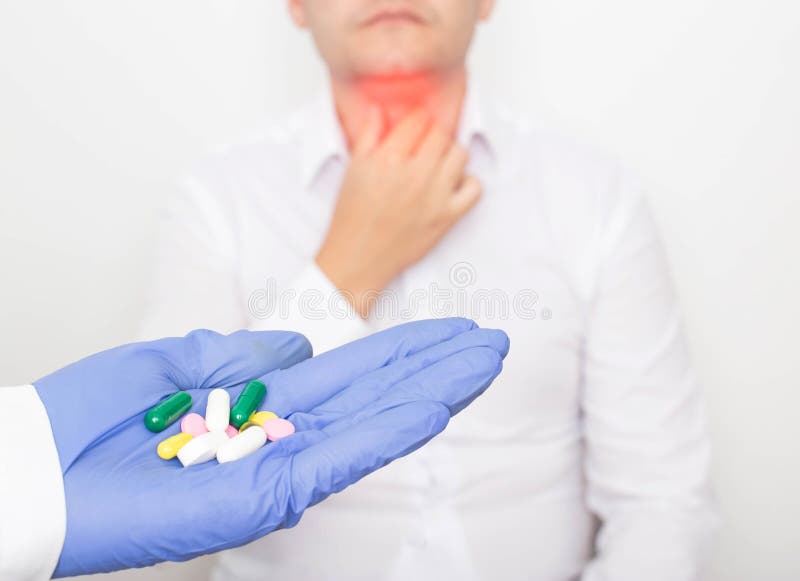 The doctor holds pills in his hand against the background of a man with a diseased thyroid gland. Thyroid medication concept royalty free stock photography